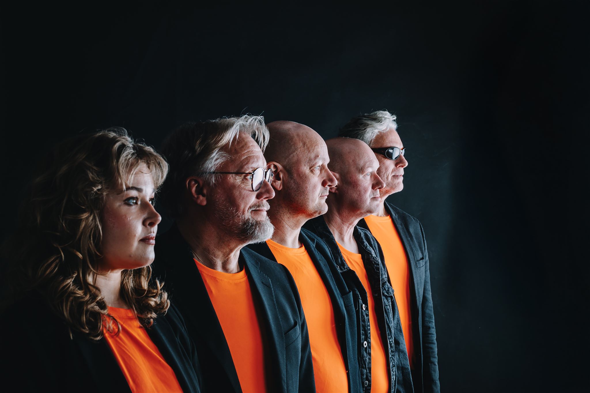 Mandarinteatern. Eddie Dubrehed, Nicklas Nordborg, Elin Wikström och Johan Seige sitter, ser glada ut och sträcker upp armarna upp i luften. Sitter på Scenen i Dalhems Bygdegård.